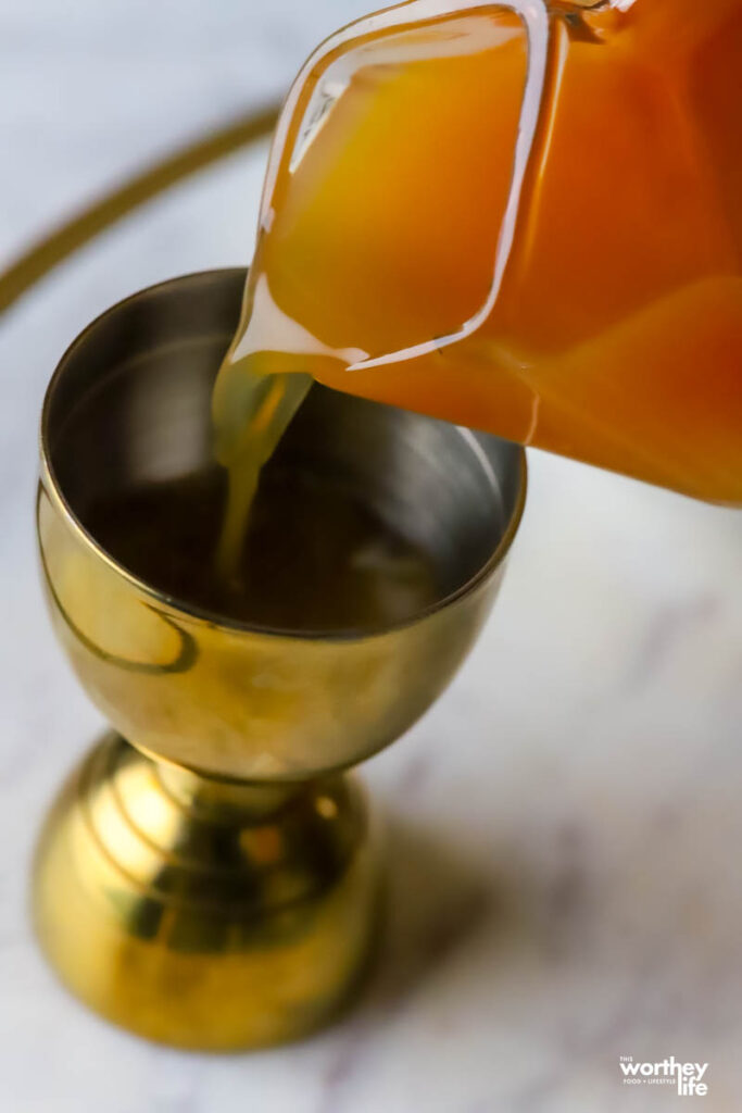 pouring apple cider in shot glass