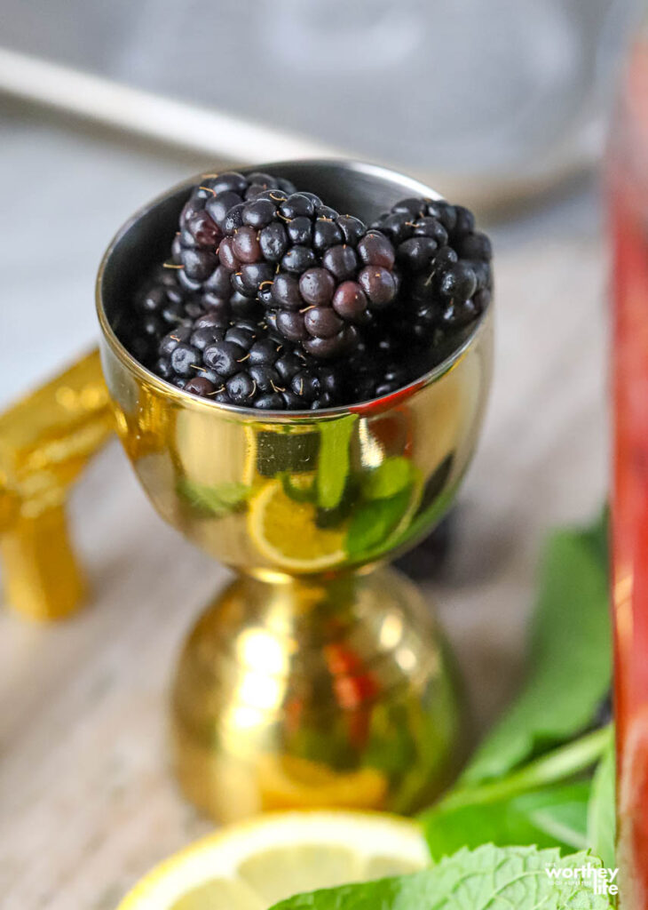 a brass jigger of blackberries