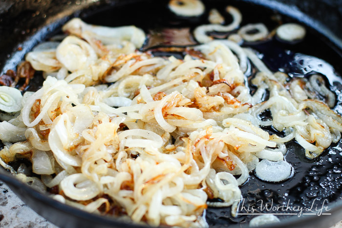 caramelized onions cooking in a cast iron skillet