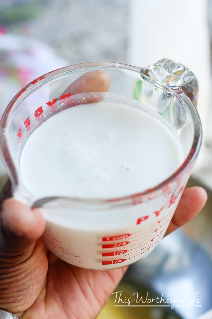 A man holding a cup of Buttermilk in a Pyrex Glass