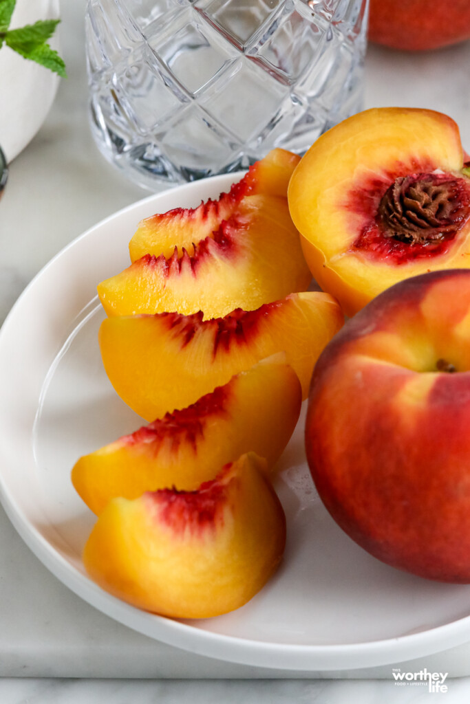 fresh sliced peaches on a white plate