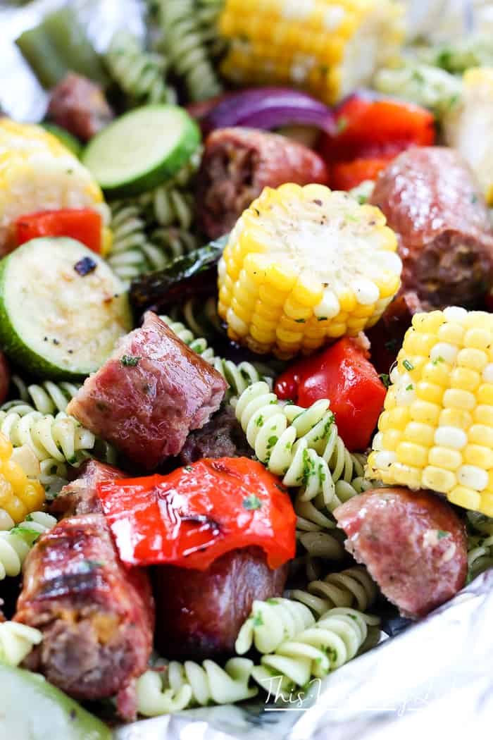 We're celebrating #bratsgiving with a fun twist on the classic crab + shrimp boil foil packets recipe by using pasta with herbs, bratwurst, and fresh veggies.