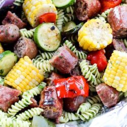 We're celebrating #bratsgiving with a fun twist on the classic crab + shrimp boil foil packets recipe by using pasta with herbs, bratwurst, and fresh veggies. 