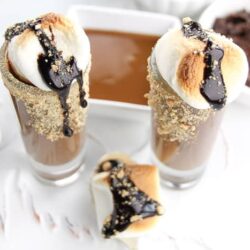 Warm up this winter with a shot of chocolate liqueur, caramel sauce, graham crackers, and chocolate syrup. Our S'mores Hot Chocolate Shots is a way to welcome in the cooler weather. And you can have it made two ways, one for you, and one for the kids. Grab the recipe for our hot chocolate cocktail on the blog!