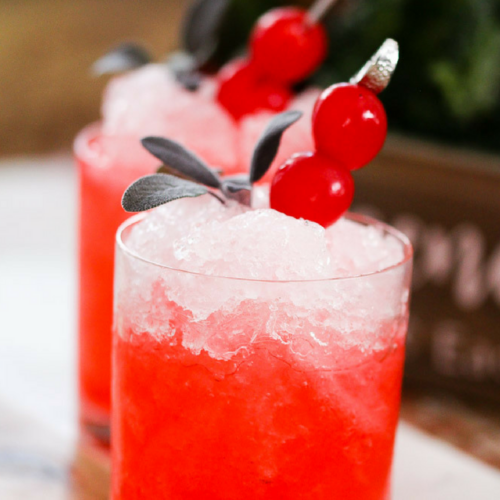 Get Christmas in a cup with our Cherry Christmas mocktail idea. Filled with cherry soda, peppermint syrup, and cherries, this frozen drink idea is a great drink idea for your holiday party.