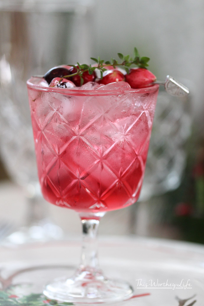 Celebrate the holiday with this fun holiday mocktail drink idea. It's filled with cranberries, sparkling juice and mint mixed all together to make a Cranberry Spritzer.