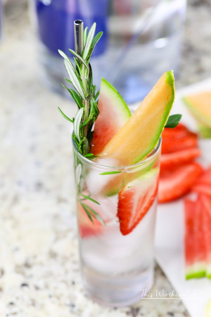 Glass with fresh fruit, finding creative ways to drink more water. 