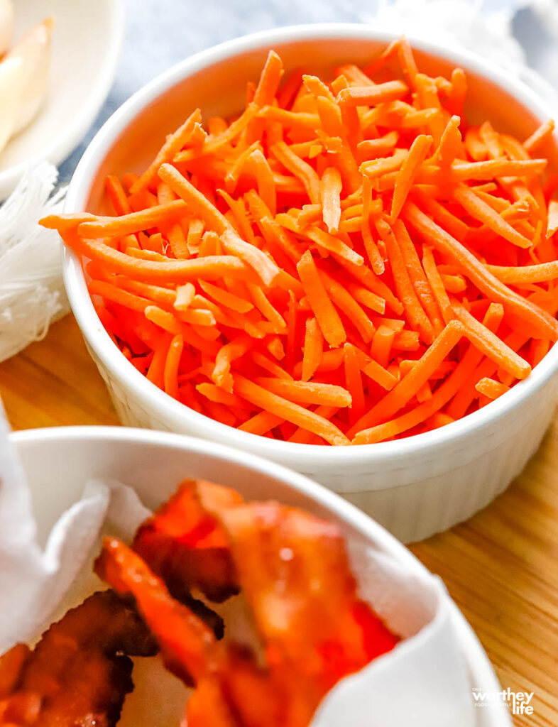 fresh shredded carrots in a white small bowl