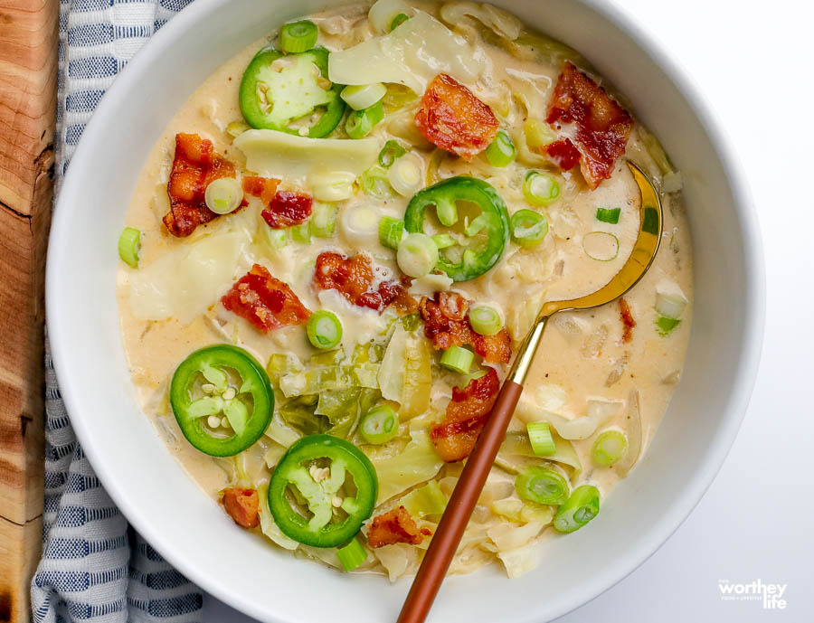 soup in a white bowl on a white background with blue cloth napkin