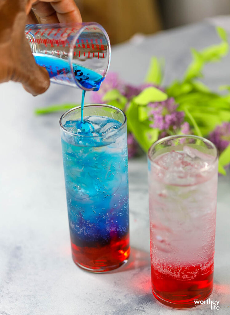 pouring blue syrup in red drink