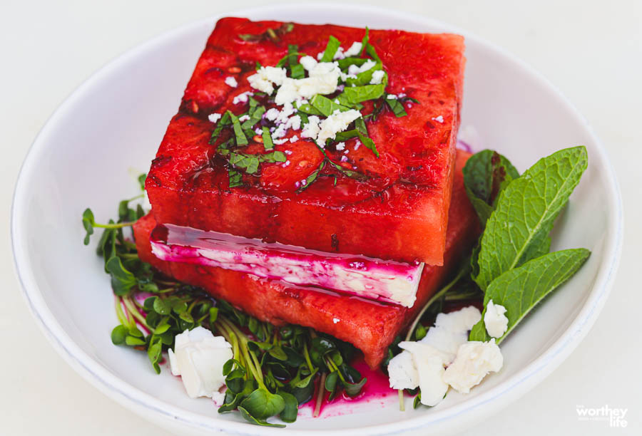 feta cheese and watermelon on white plate with fresh greens