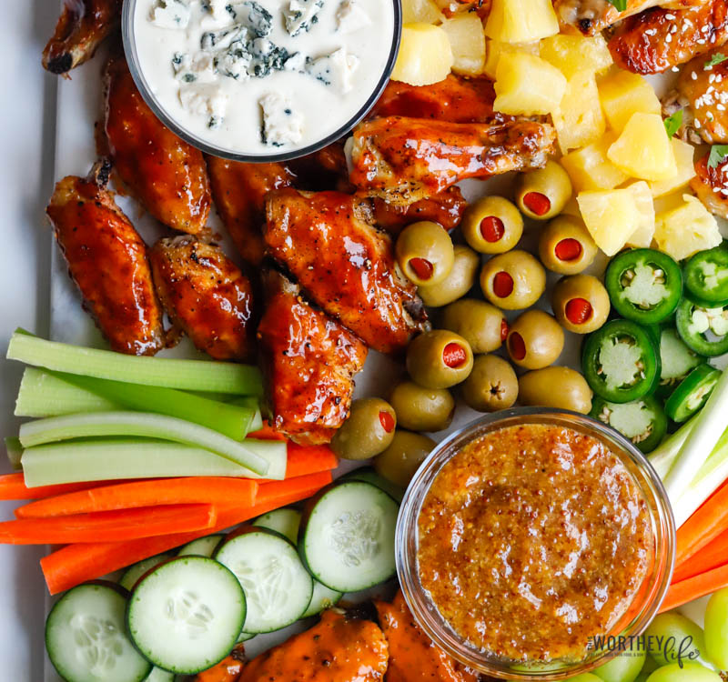 grazing board with three different type of chicken wings and dips
