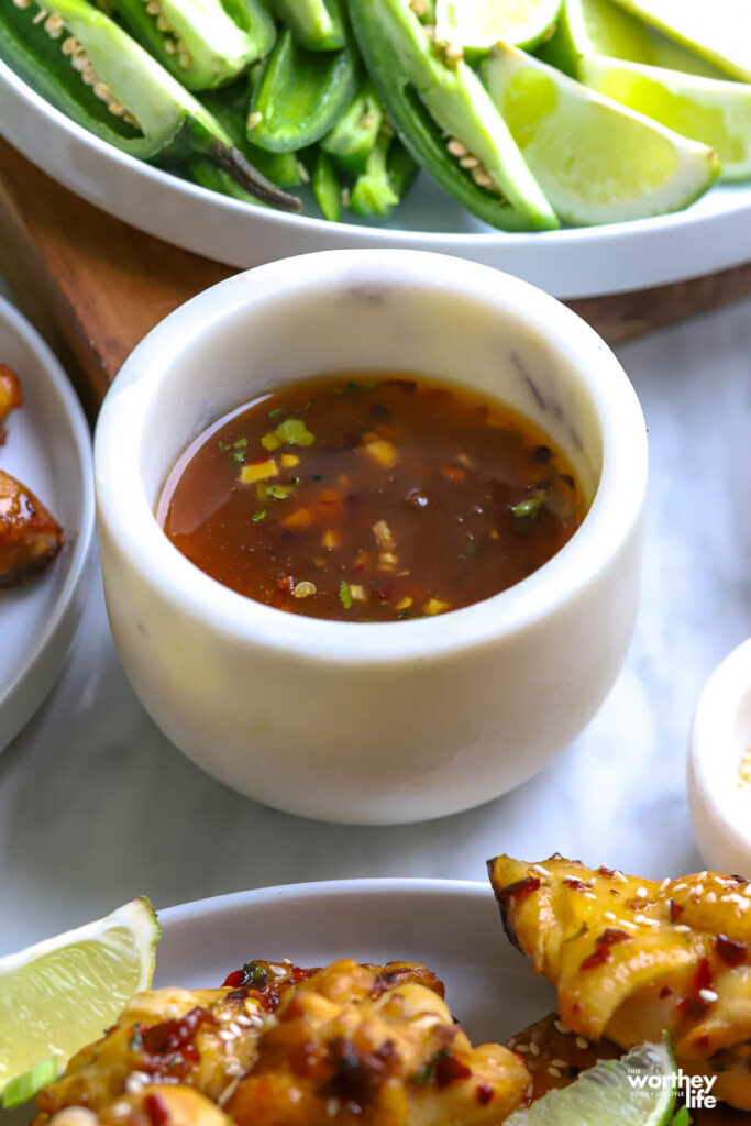 A white serving bowl of Thai dipping glaze. 