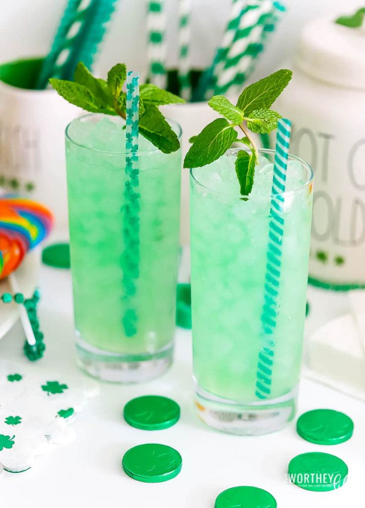 two tall glasses filled with green drink and mint