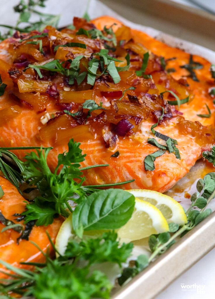 cooked slab of salmon with fresh mint, caramelized onions and pineapples