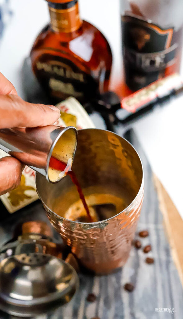 pouring dark rum into a cocktail shaker