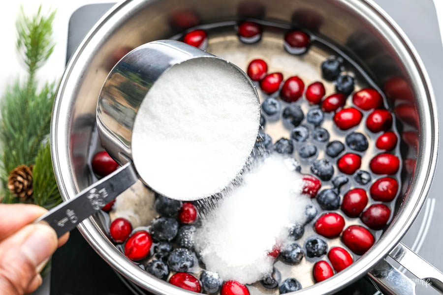 saucepan filled with blueberries, cranberries, and sugar