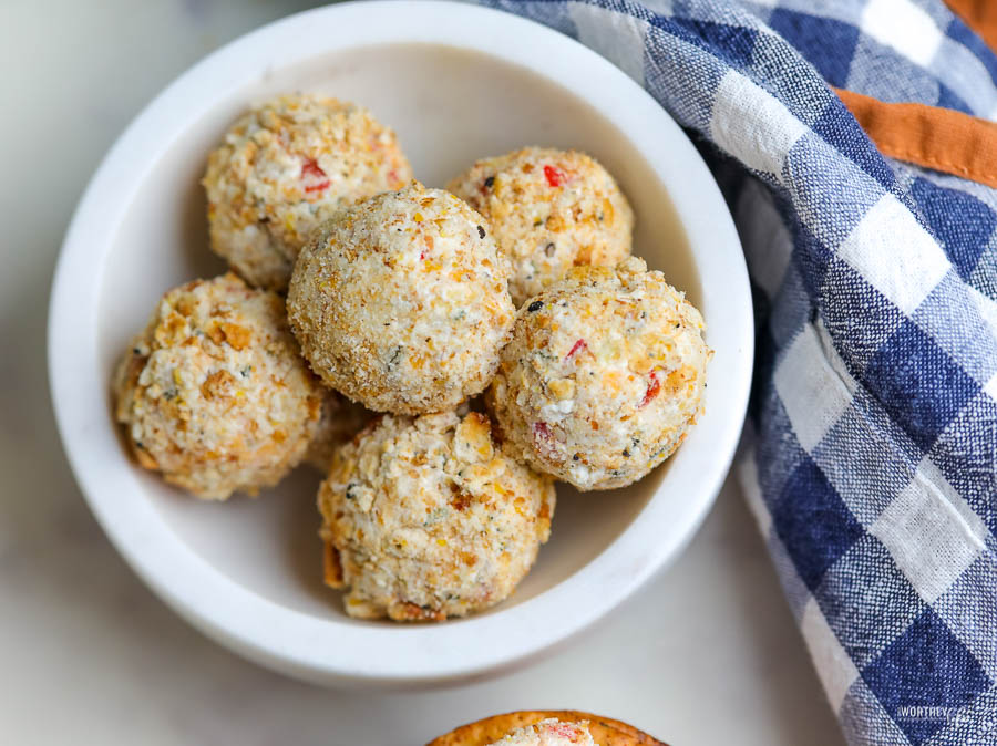 a white stone bowl filled with savory homemade cheeseballs