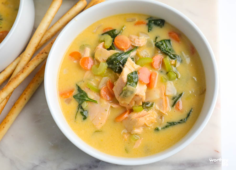 white serving bowl filled with delicious salmon and spinach soup