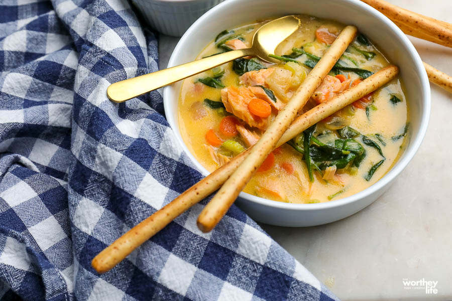 a bowl filled with hot salmon soup with spinach