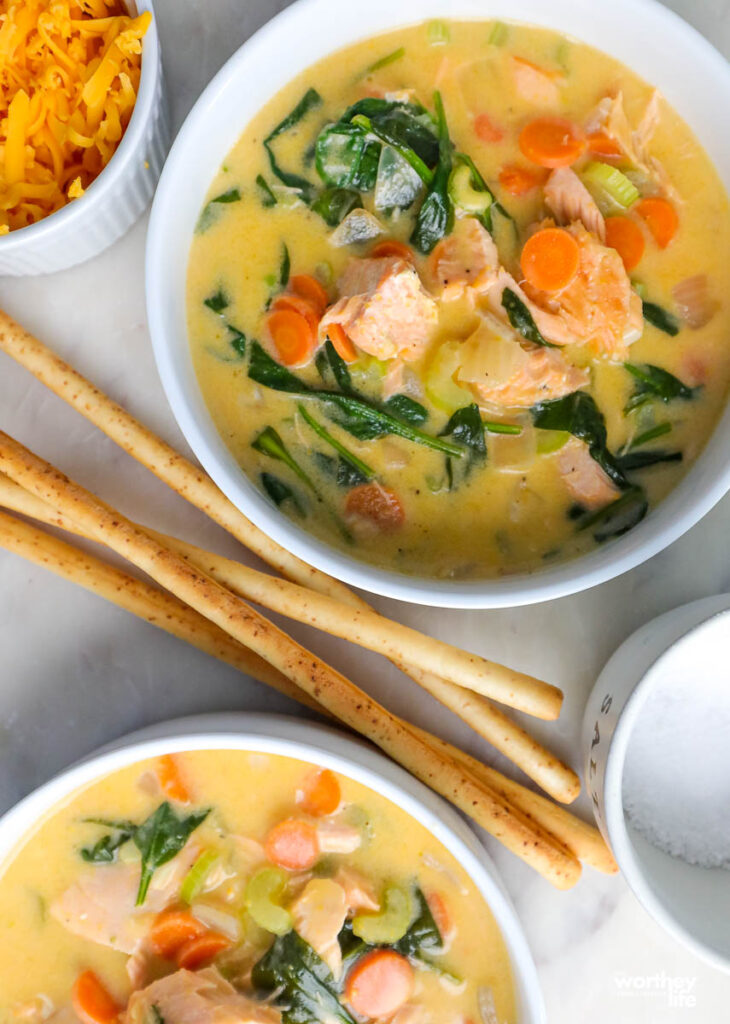 bowls with salmon soup and long breadsticks