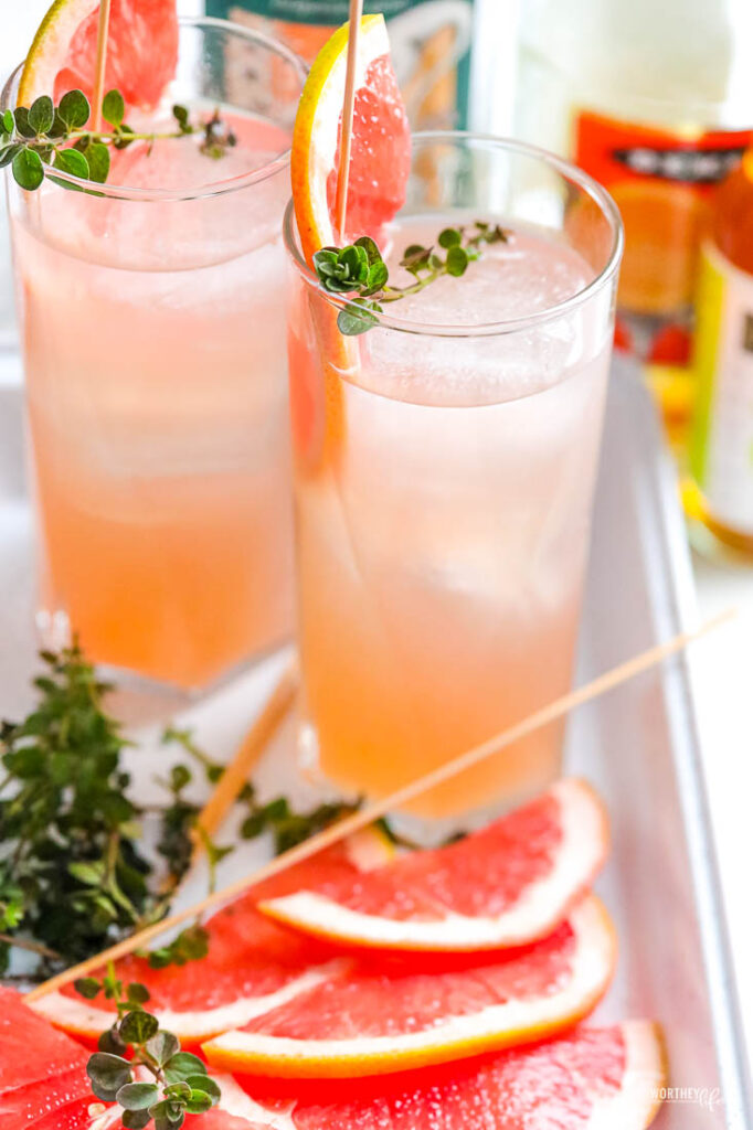 fruit gin cocktail with two glasses and fresh grapefruit