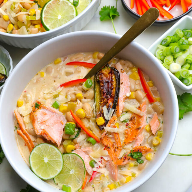 white chili salmon in a white bowl with fresh veggies
