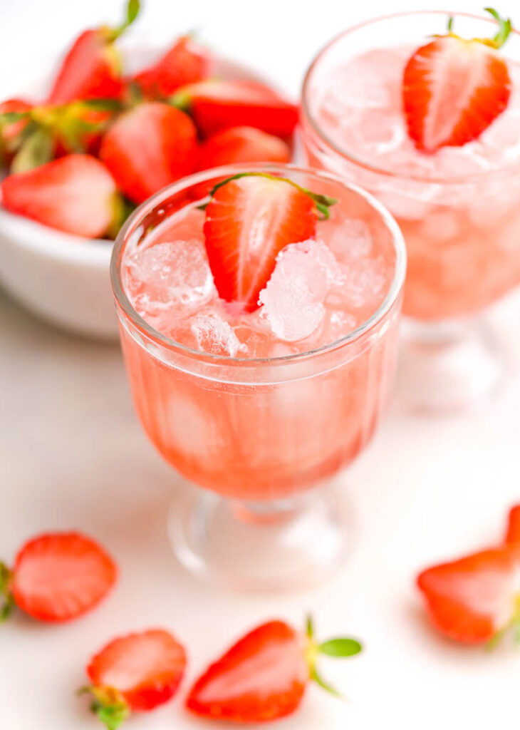 cranberry mocktail with fresh strawberries on a white background