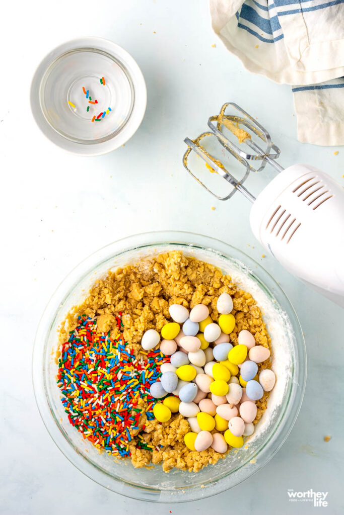 cookie dough in a clear bowl with mixer