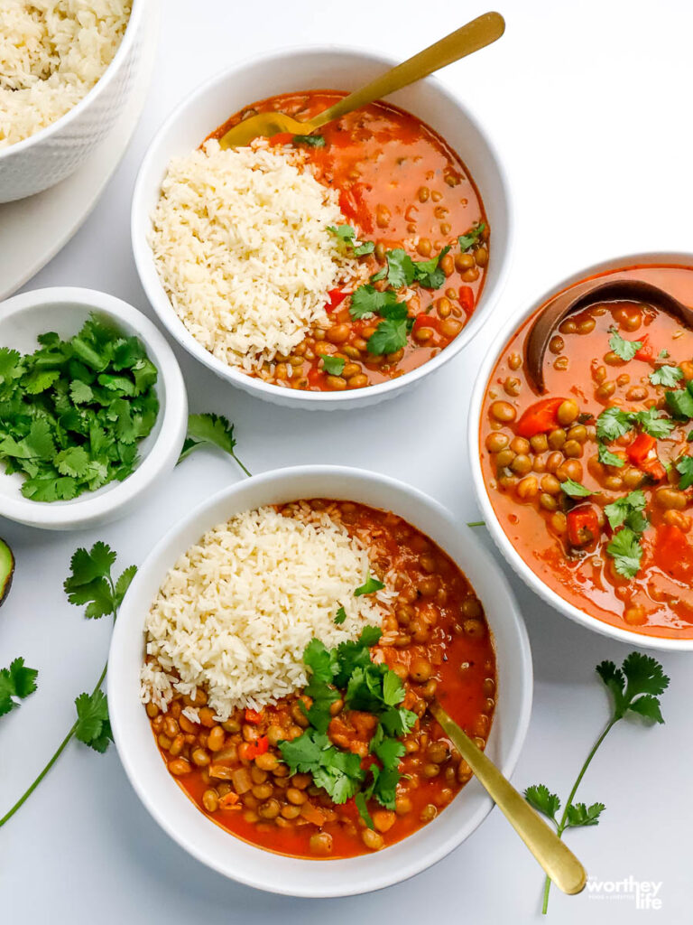 white serving bowls filled with pigeon pea stew and jasmine rice