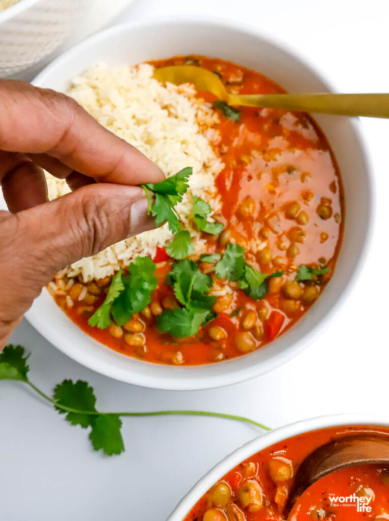 adding chopped cilantro to pigeon pea soup