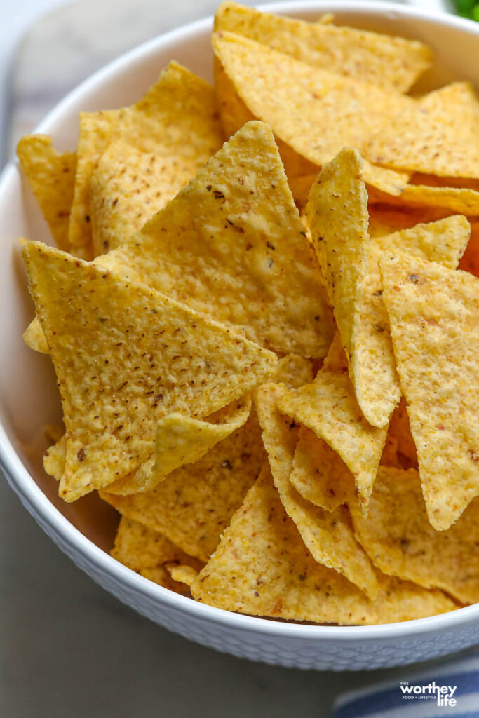 a large white serving bowl filled with corn tortilla chips