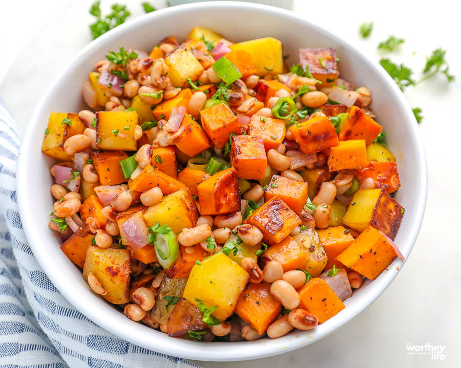 a white bowl filled with sweet potato and black eyed peas hash