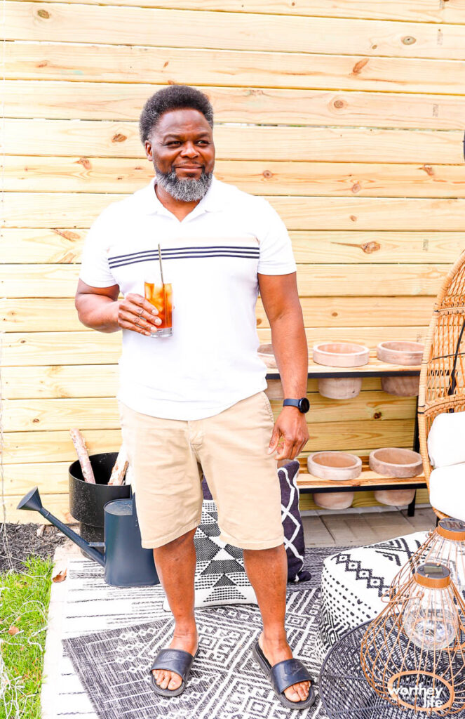 a man drinking ice tea on the patio