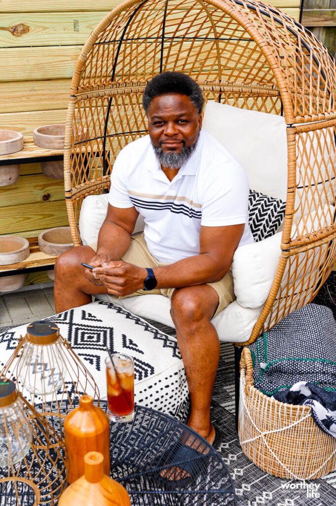 a man sitting in a lounge chair wearing summer clothes