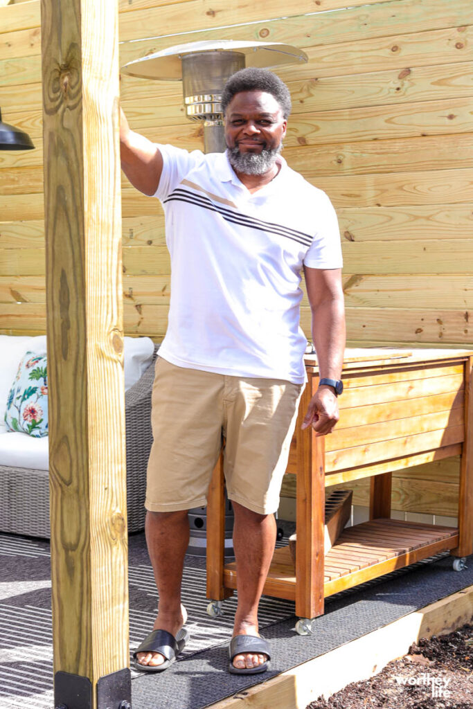 man wearing shorts and a polo shirt with his arm raised