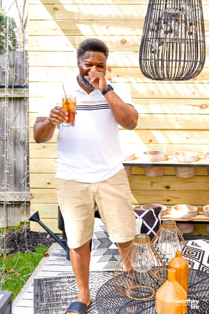 a man standing with a glass of ice tea in his hand