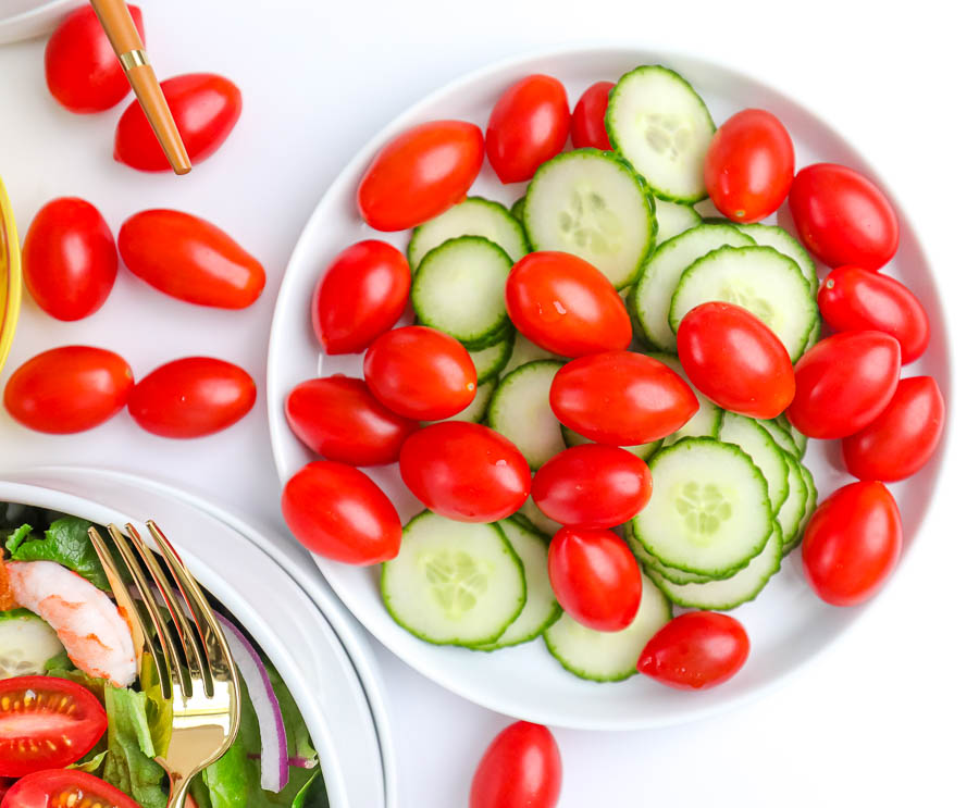 fresh tomatoes and cucumbers on a white plate