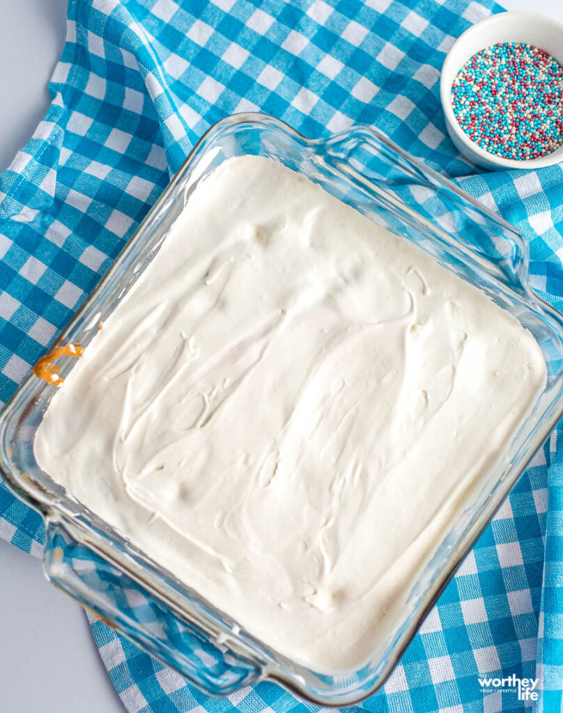 cake with icing on it in a glass baking pan