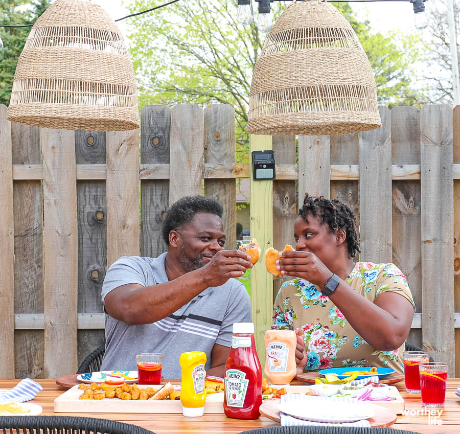 couple enjoying grilled burgers outside