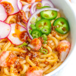 soba noodle salad in a white bowl with fresh vegetable toppings