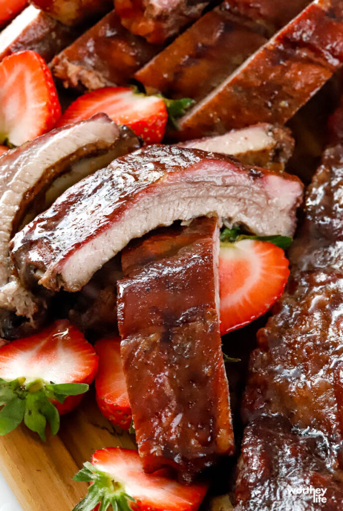slices of baby back ribs with slices of strawberries