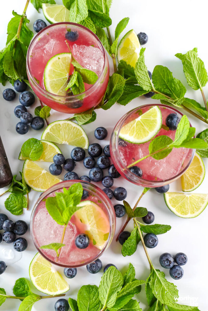 Blueberry Mojito in three glasses with fruit 