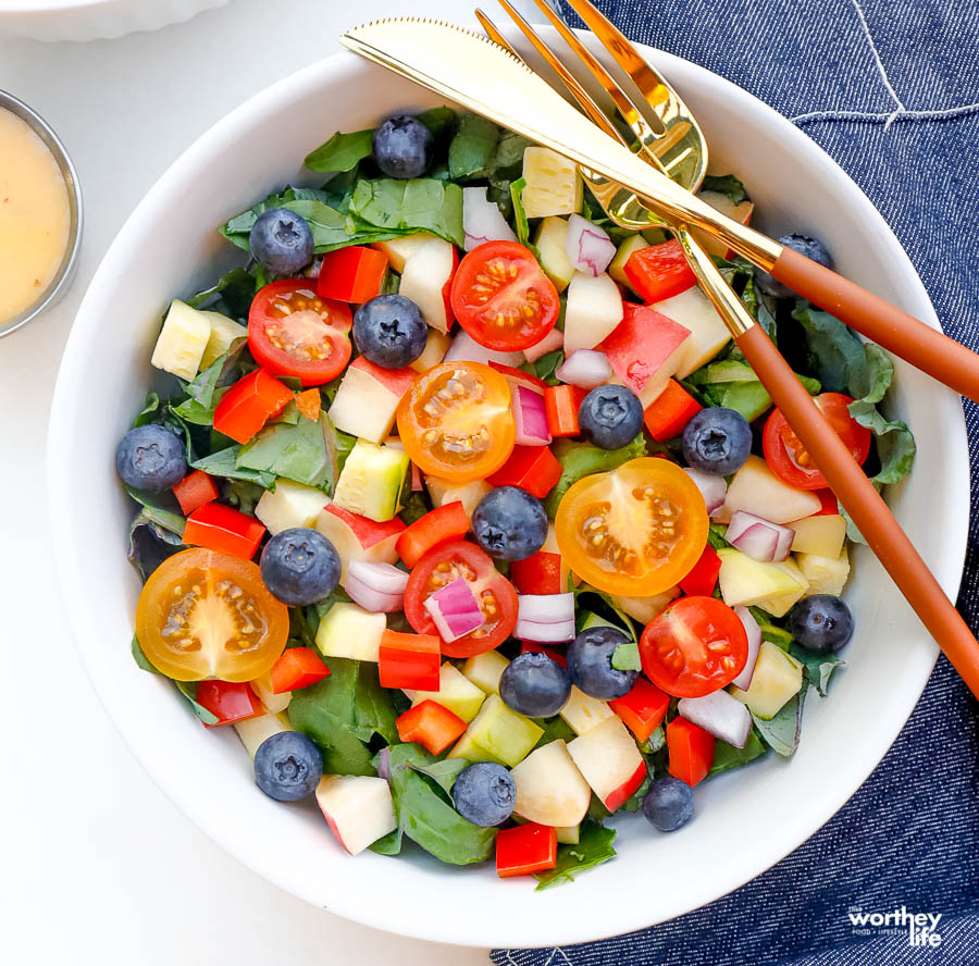 fresh, ripe salad greens with sweet juicy fruits like blueberries and apples mixed in a salad bowl