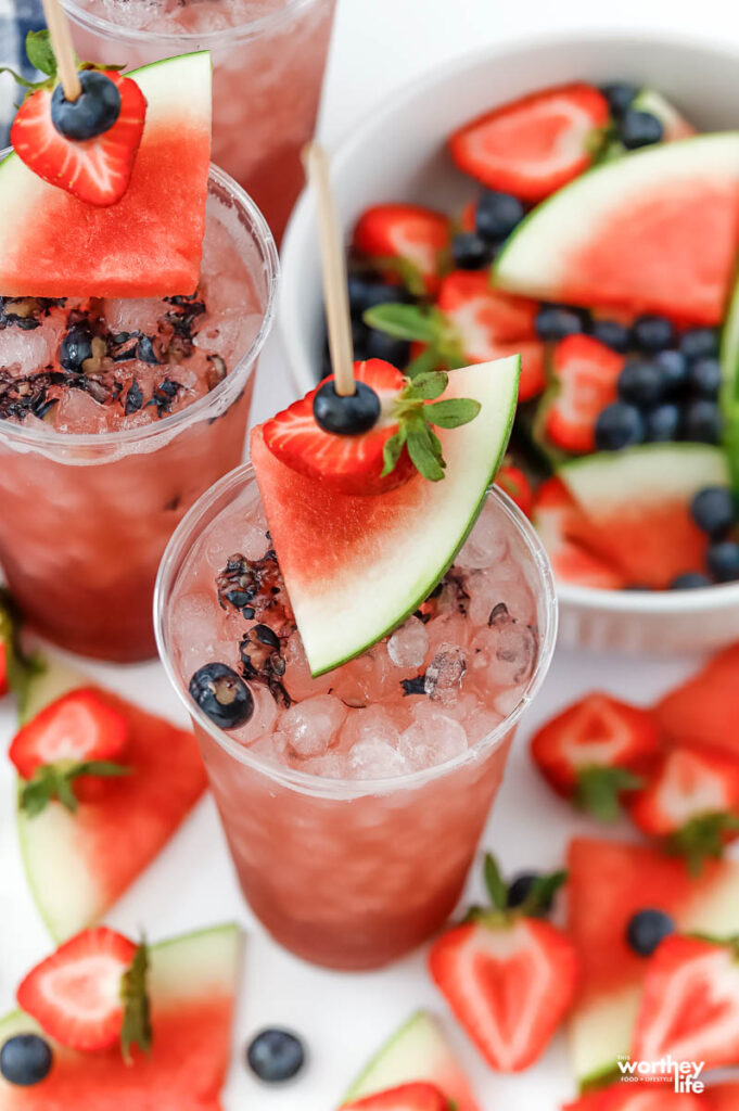 two party cups filled with a fruit filled spiked Watermelon Vodka Punch