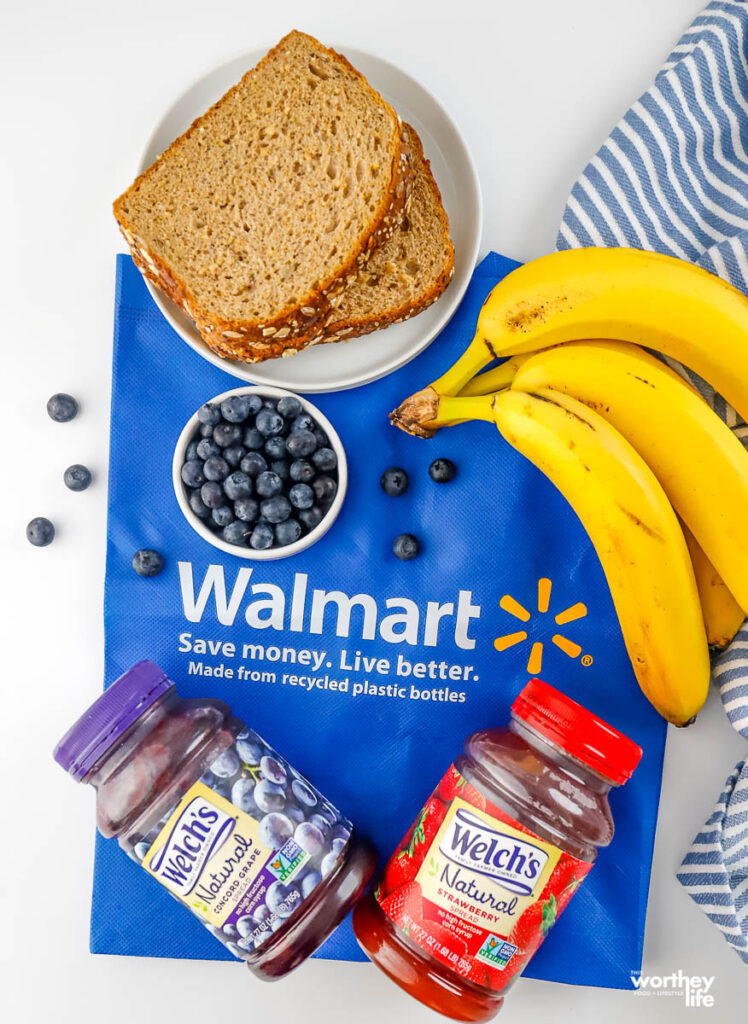 jars of concord grape and strawberry spread, blueberries, bananas, and bread