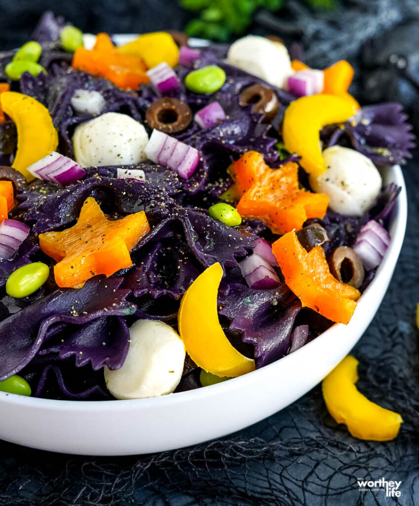 halloween pasta salad in white bowl with black background