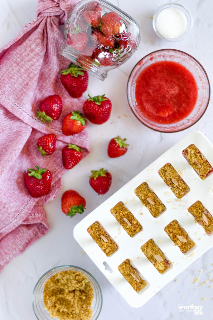 the making of Strawberry + Coconut Milk Crumble Popsicles on a white background