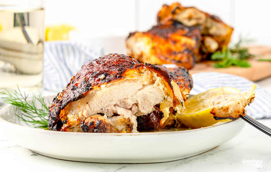 Marinated Chicken Thighs cut in half on a white plate