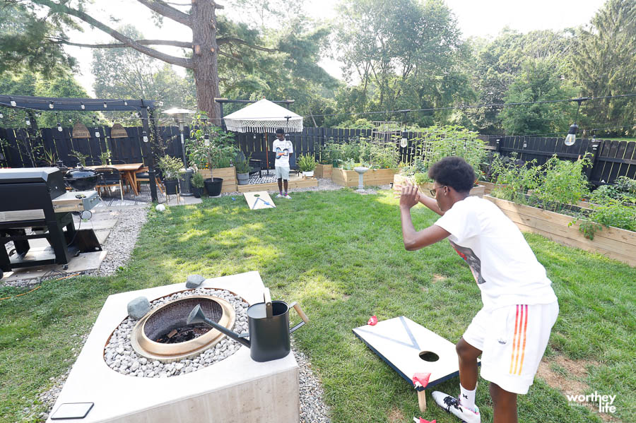 teens playing cornhole in the backyard